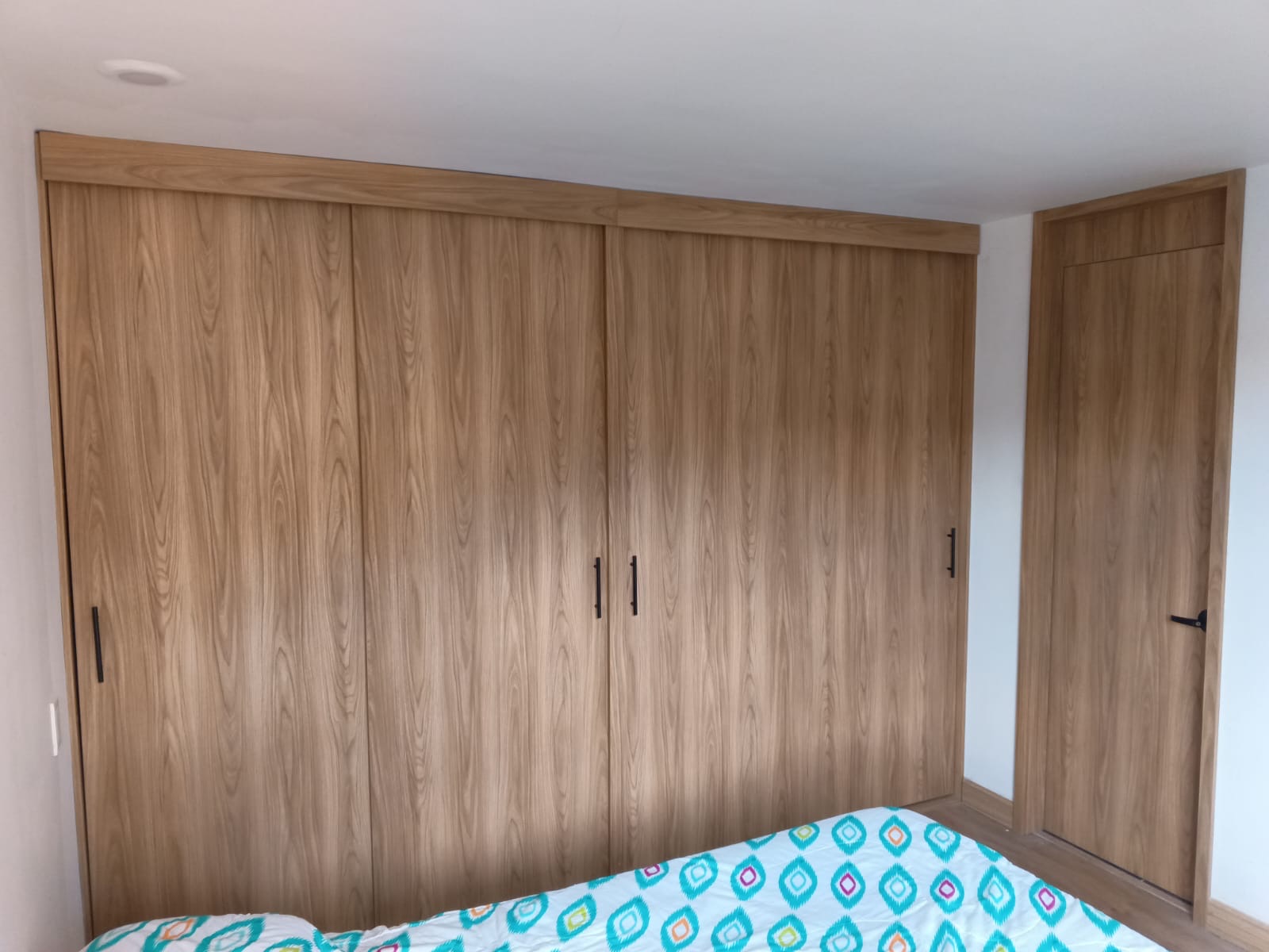 Clóset de pared completa con puertas corredizas acabado roble fabricado por Moduflex